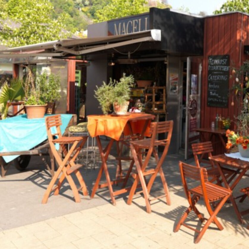 Cozy outdoor terrace of Macello with tables and plants. | © Macello