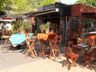 Cozy outdoor terrace of Macello with tables and plants. | © Macello