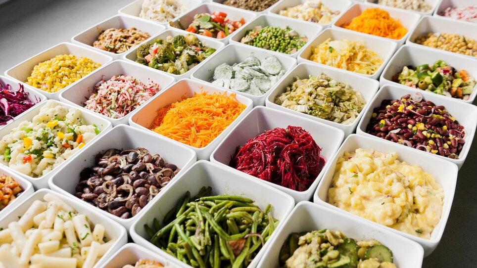 Varietà di piatti in ciotole con insalate fresche e contorni. | © Mangolds