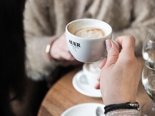 A person holds a cup of coffee in a café in Graz. | © Martin Auer 