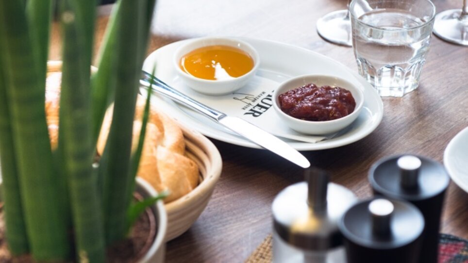 Ein gedeckter Tisch mit Getränken und Brot, umgeben von Pflanzen. | © Martin Auer