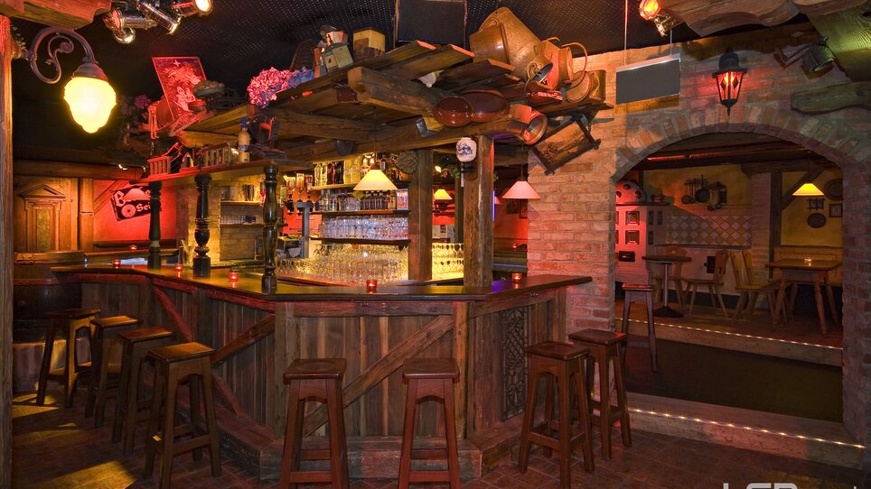 Bar accogliente con bancone in legno e bevande a Graz. | © Mausefalle +