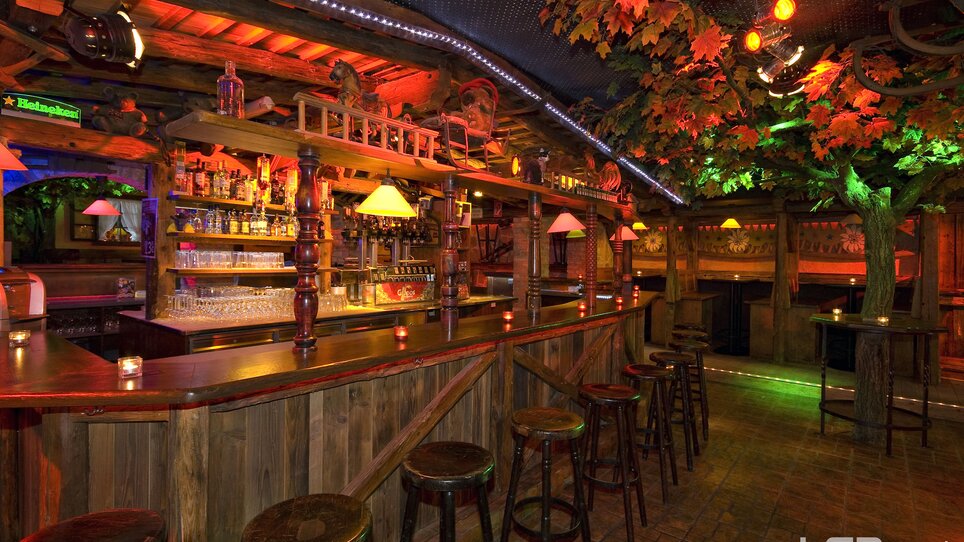 Bar accogliente con luci colorate e decorazioni in legno. | © Mausefalle +
