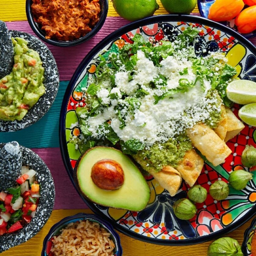 Un piatto colorato con enchiladas, guacamole, insalata e contorni. | © Unsplash - Sandra Seitamaa