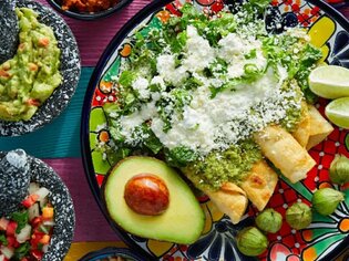 Ein bunter Teller mit Enchiladas, Guacamole, Salat und Beilagen. | © Unsplash - Sandra Seitamaa