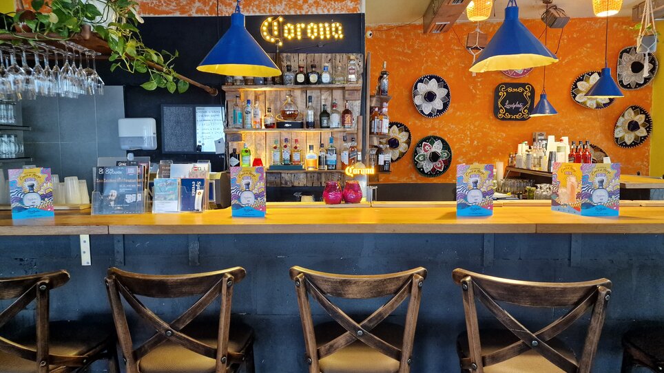 Blick auf den Barbereich mit bunten Lampen und Getränken. | © Mi Casa