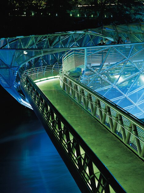 Die Murinsel bei Nacht mit beleuchtetem Steg im Wasser. | © Graz Tourismus - Harry Schiffer