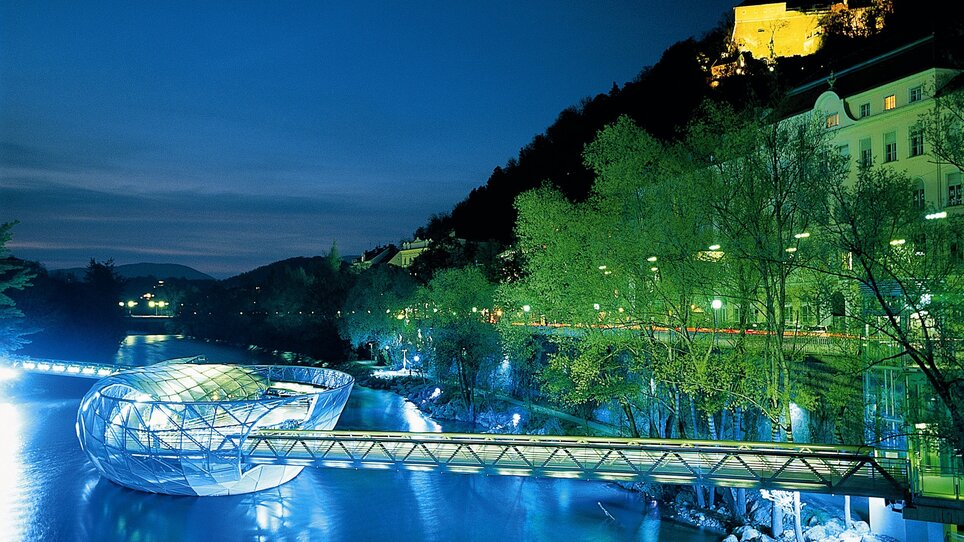 Illuminated Murinsel in Graz, at night over the Mur. | © Graz Tourismus - Harry Schiffer