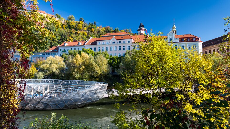 The Murinsel in Graz overlooking the Mur river and surrounding trees. | © Graz Tourismus - Harry Schiffer