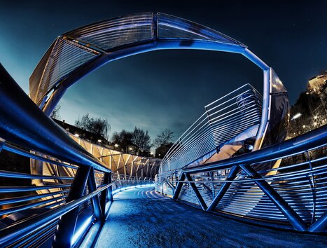 Murinsel illuminata a Graz di notte, architettura moderna. | © Graz Tourismus - Nicolas Galani