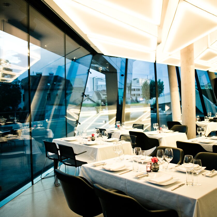 Elegant restaurant in Graz with modern furniture and panoramic view. | © nullneun