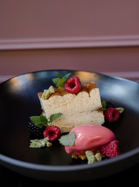 Ein kunstvoll angerichtetes Dessert mit Torte und Sorbet. | © Joel Kernasenko