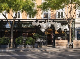 Modern restaurant facade with balloon decoration and colorful atmosphere. | © Jauk Katharina