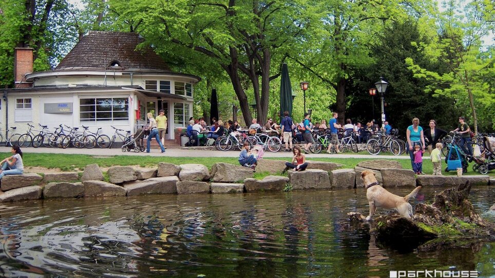 View of Parkhouse in Graz City Park with people and a dog. | © Huber