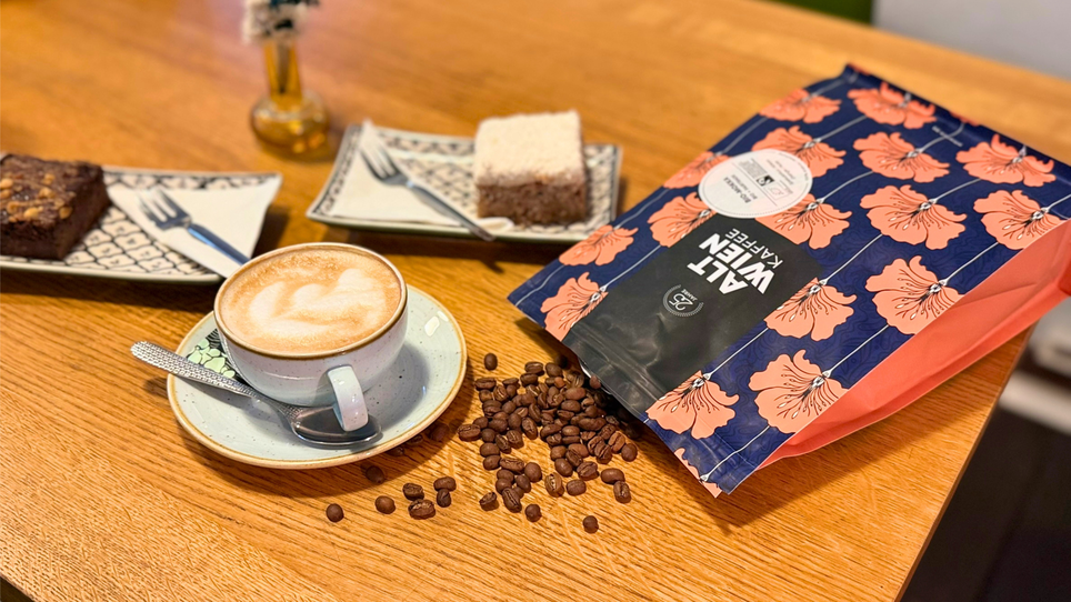 Tazza di caffè, un dolce e un sacchetto di caffè su un tavolo. | © Graz Tourismus