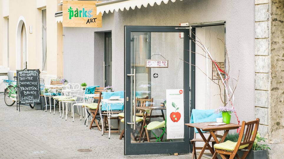 Coffee shop in Graz with outdoor seating and open door. | © Martin Pabis & Martina Rötzer