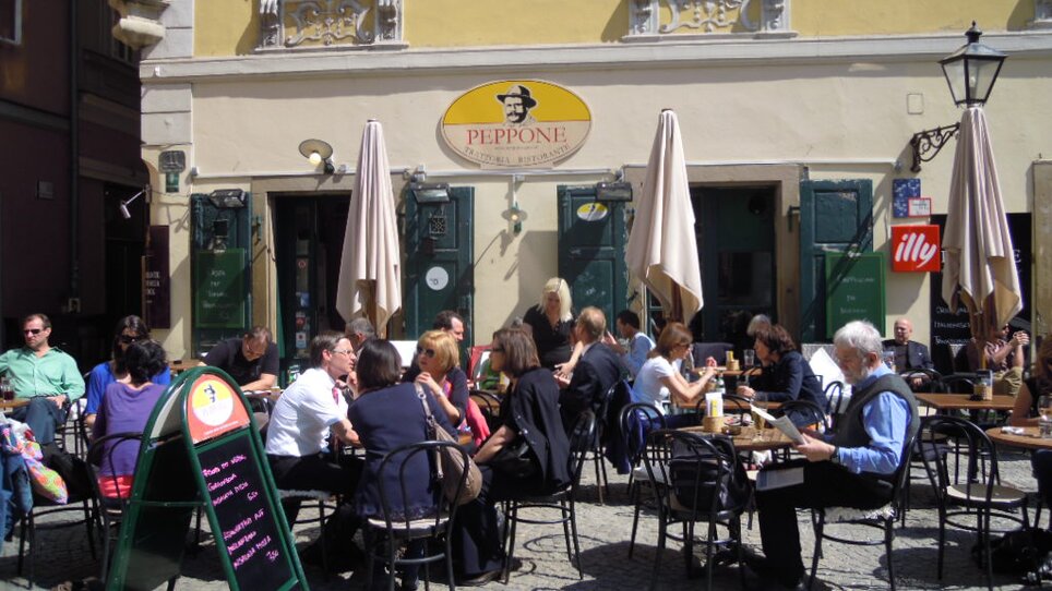 People enjoy food and drinks outside Peppone restaurant in Graz. | © CMS