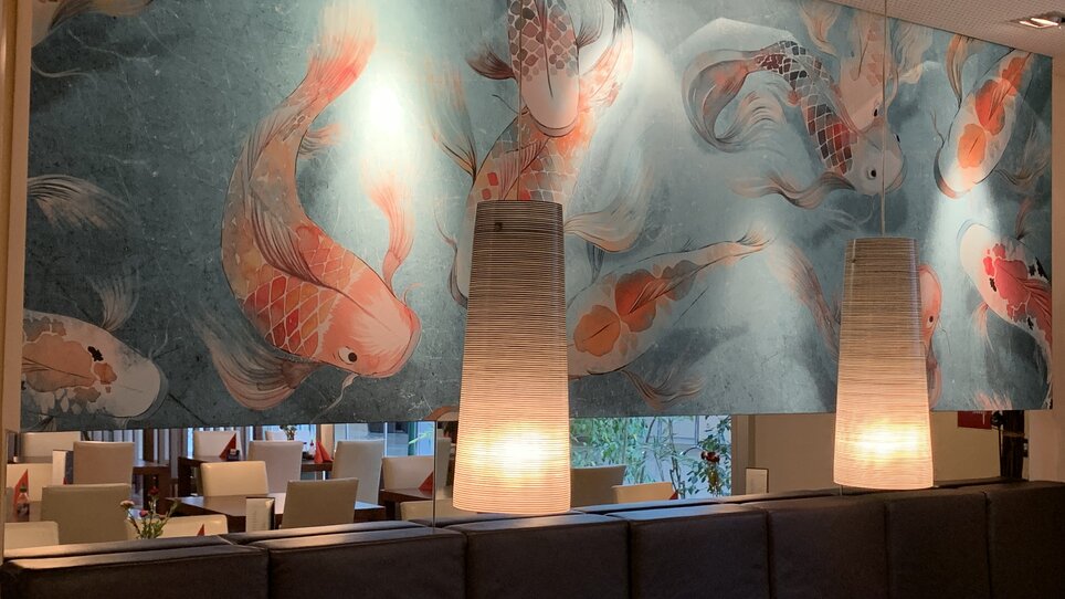 Cozy restaurant atmosphere with artistic fish mural.