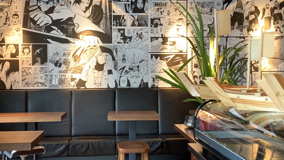 Cozy restaurant area with manga wall decoration.