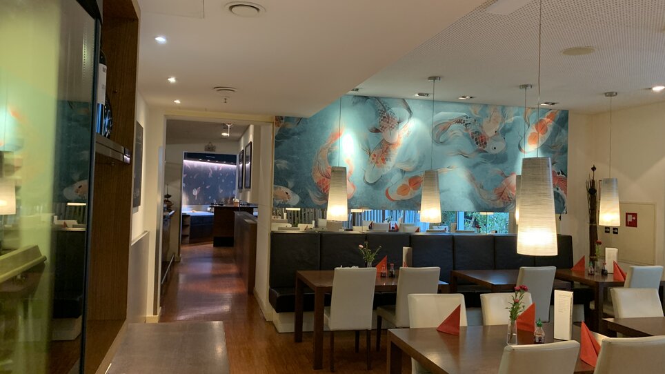 Cozy restaurant with Asian decor and wall mural.