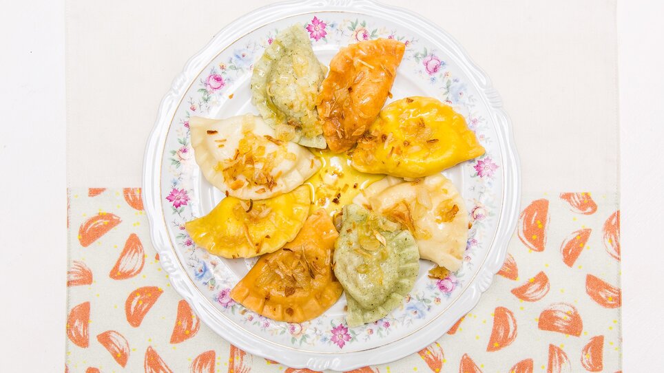 A variety of colorful pierogi on a plate.