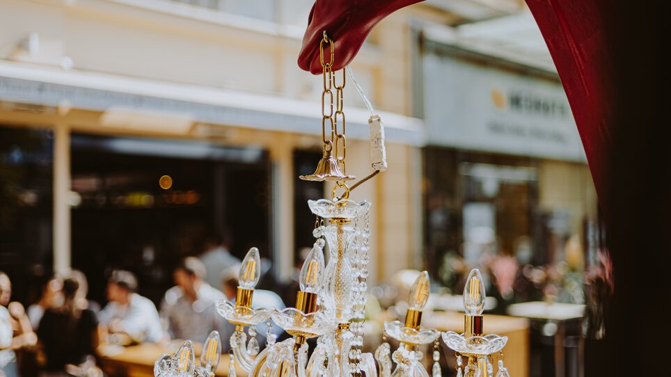 A red horse holds up a sparkling chandelier. | © Joel Kernasenko