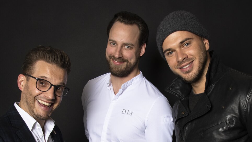Three men showcase a dish on a plate. | © Jauk Katharina