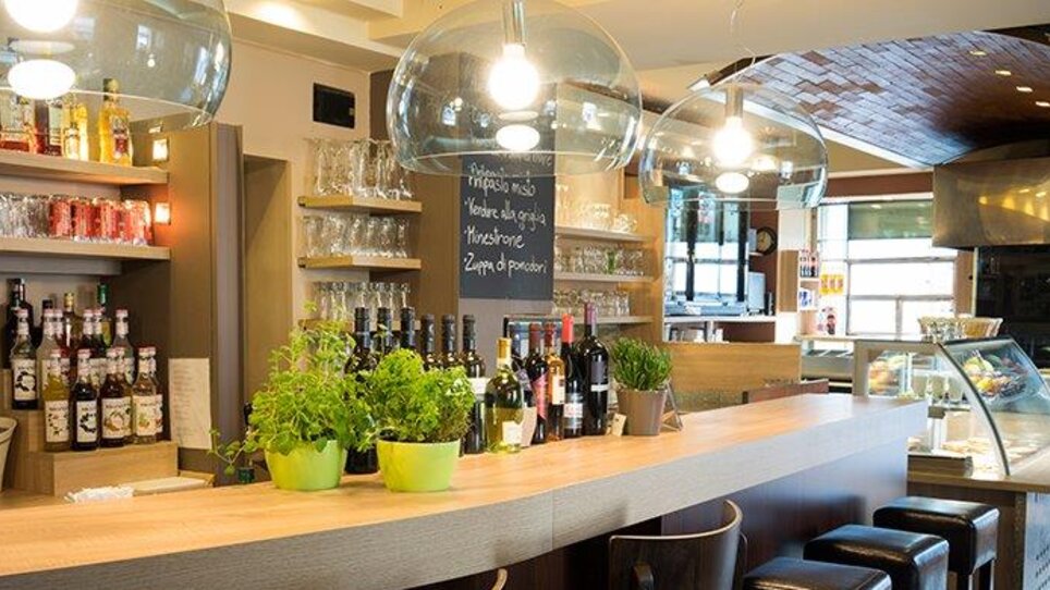 Bright pizzeria with modern design, full bar, and plants. | © Pizzeria Santa Catharina