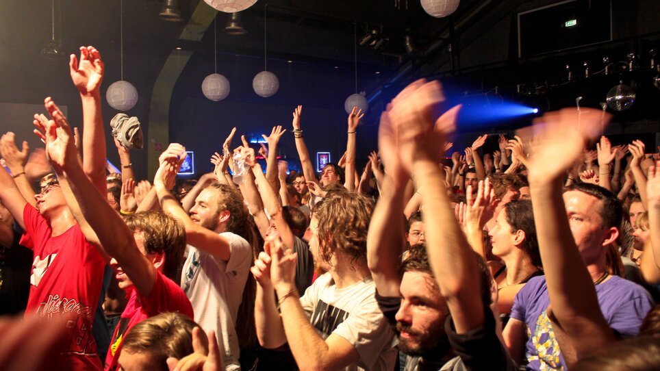 Crowd at a concert raising hands in the air. | © ppc