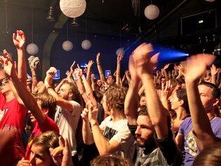 Menschenmenge bei einem Konzert, die die Hände in die Luft hebt. | © ppc
