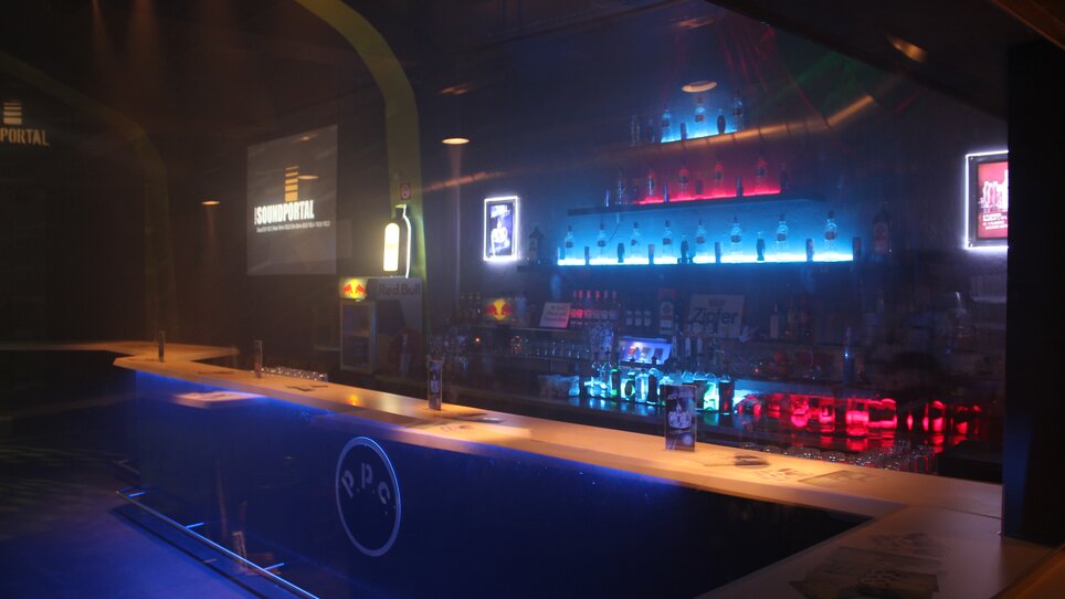 Illuminated bar with drinks and modern ambiance. | © ppc
