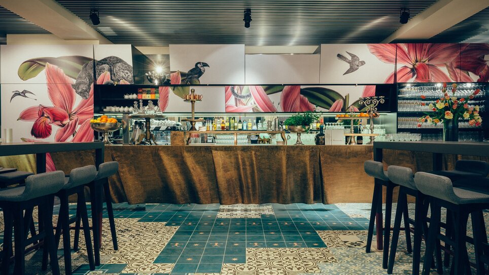 Café Promenade I Mangiare e bere a Graz | © Promenade - Joel Kernasenko Area bar moderna con motivi floreali alle pareti e sedie eleganti. | © Promenade - Joel Kernasenko