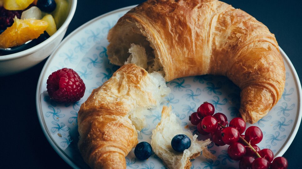Café Promenade I Mangiare e bere a Graz | © Promenade - Joel Kernasenko Un croissant fresco su un piatto con bacche e insalata di frutta. | © Promenade - Joel Kernasenko