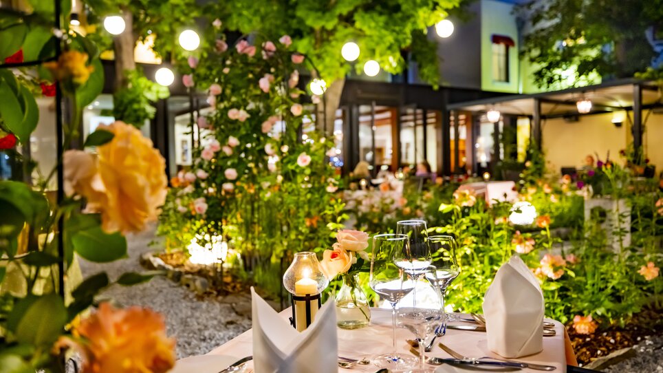 Ristorante all'aperto accogliente, splendidamente illuminato con rose e candele. | © Florian im Parkhotel