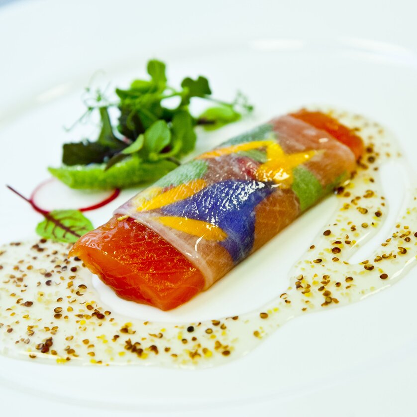 Revita Catering I Eat & Drink in Graz A creatively plated dish with salmon and colorful vegetables.