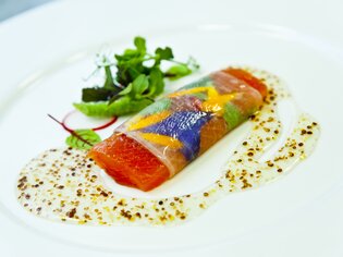 A creatively plated dish with salmon and colorful vegetables.
