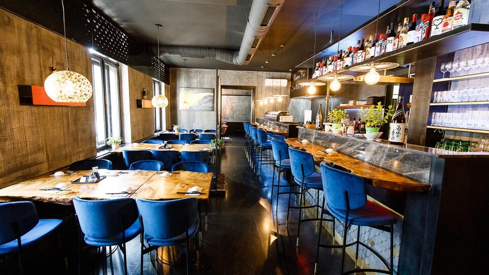 Elegant Asia Restaurant Sakana with blue chairs and wooden decor.