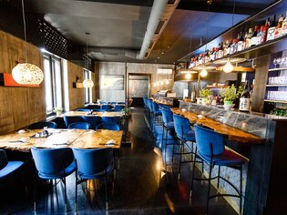Elegant Asia Restaurant Sakana with blue chairs and wooden decor.