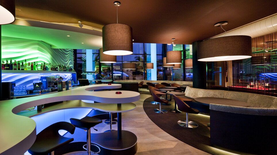 Modern bar with stylish lighting design and seating areas. | © San Pietro - Werner Krug