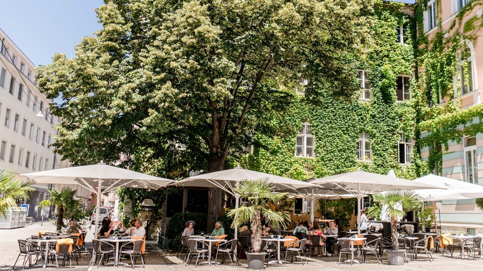 Gemütliche Außenterrasse eines Restaurants in Graz mit Tischen und Stühlen. | © Schäffner