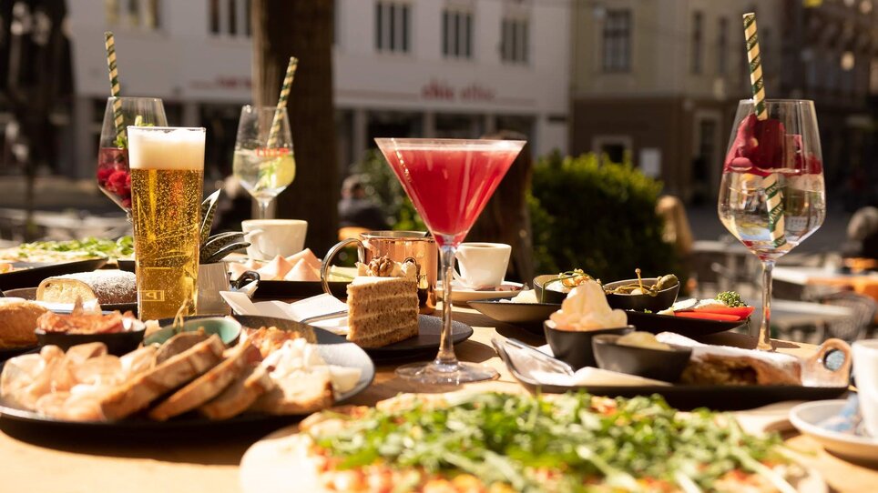 Vielfältige Speisen und Getränke in Graz auf einem Tisch.