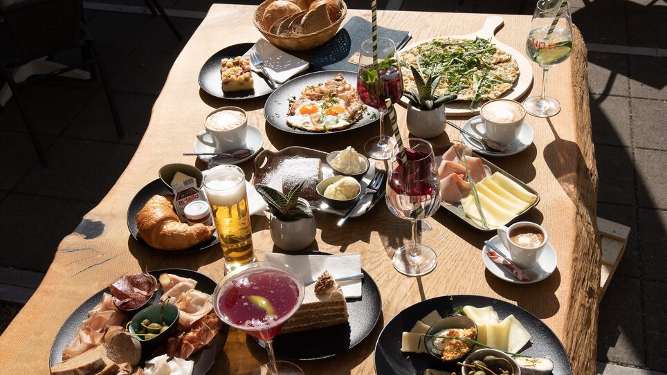 Ein Tisch mit verschiedenen Speisen und Getränken zum Frühstücken in einem Cafe in Graz.