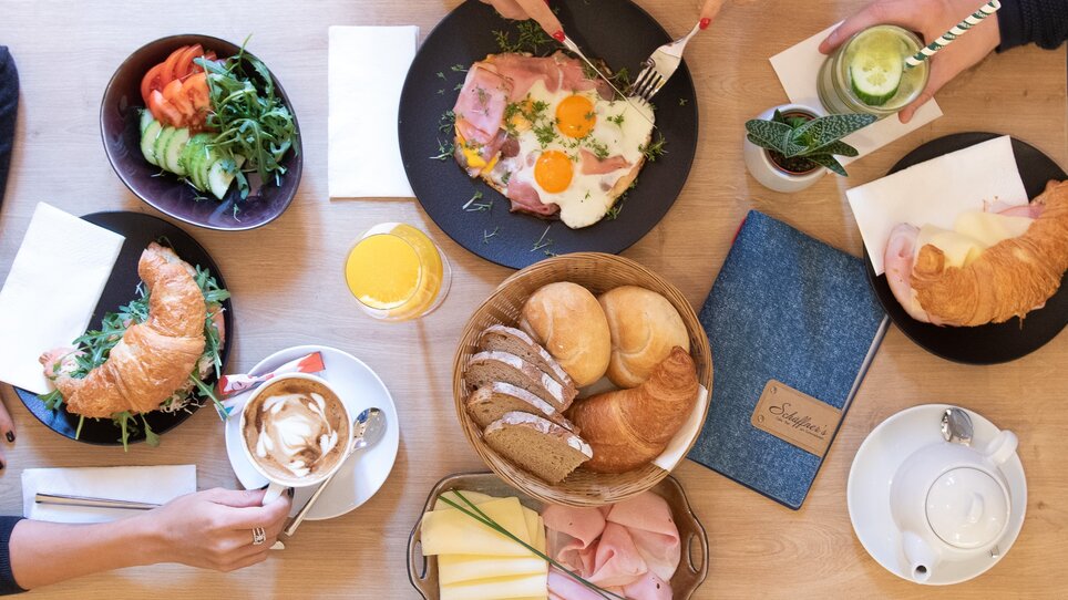 Ein Tisch mit vielfältigem Frühstücksangebot und Getränken.
