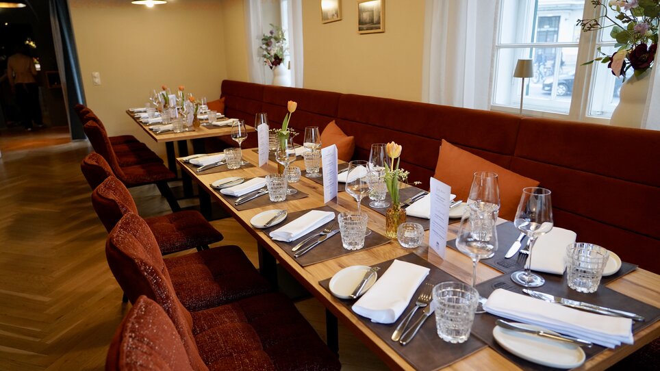 Gedeckter Tisch im Schanzlwirt mit Blumen und Gläsern. | © Wirtshaus Schanzlwirt