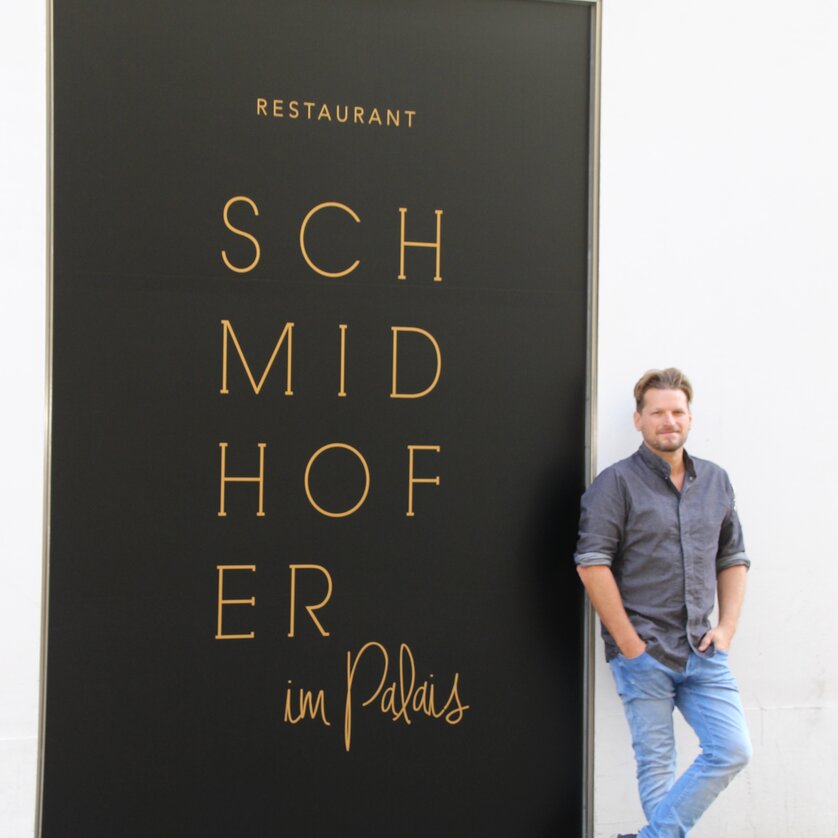 Mann steht vor dem Schmidhofer Restaurant in Graz.