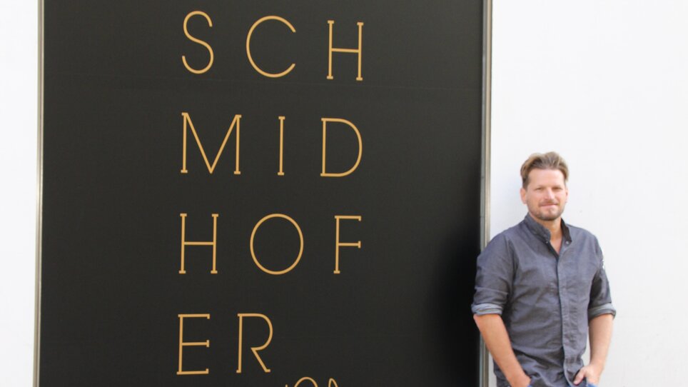 Mann steht vor dem Schmidhofer Restaurant in Graz.