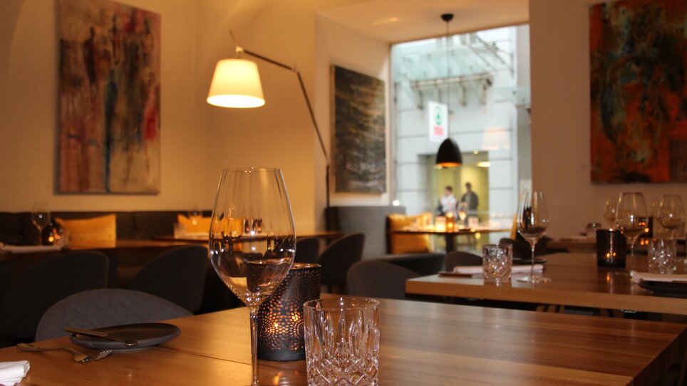 Stylisches Restaurantinterieur mit Kunstwerken und stimmungsvollem Licht.