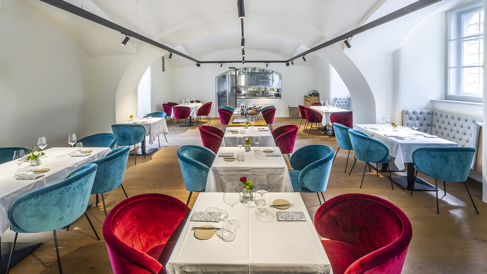 Elegant restaurant with colorful chairs and set tables. | © Paul Stajan