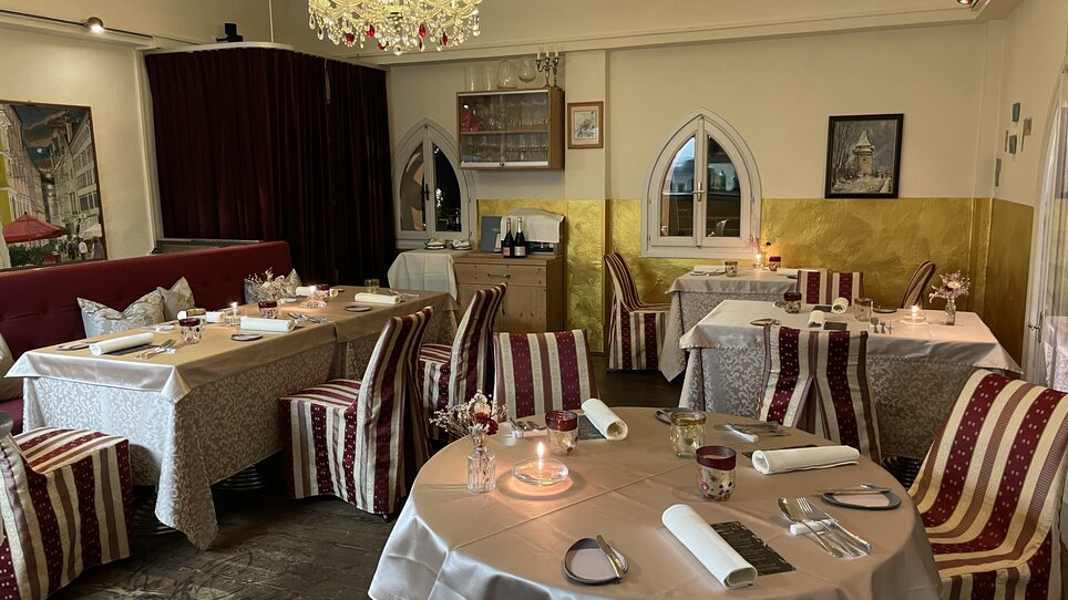 Elegante Restaurantansicht mit Tischen und Stühlen, Kerzenlicht und einem Kronleuchter. | © Starcke Haus