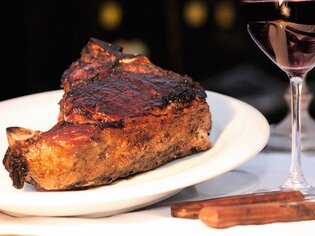 A juicy steak on a plate next to a glass of red wine. | © Steak Boutique